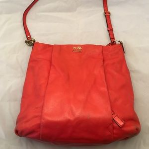 Orange-red Coach cross-body leather bag.